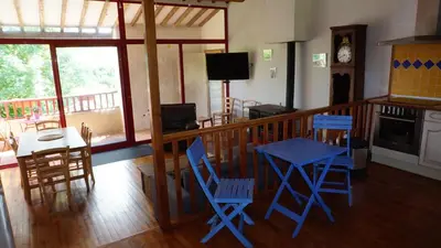 a living room with blue chairs and a table at Terres de Barréjat in Cazals-des-Baylès