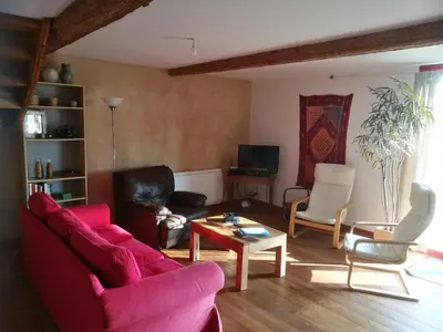 a living room with a red couch and chairs at Terres de Barréjat in Cazals-des-Baylès