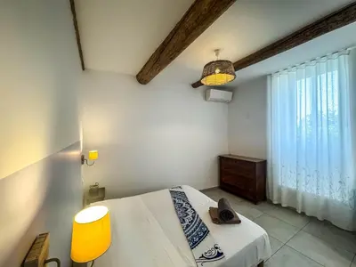 a bedroom with a bed and a window at La Turquoise in Caves