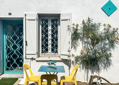 a patio with a table and chairs in front of a door at La Turquoise in Caves