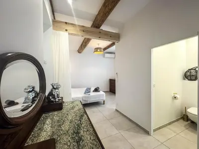 a bathroom with a mirror and a bed in a room at La Turquoise in Caves