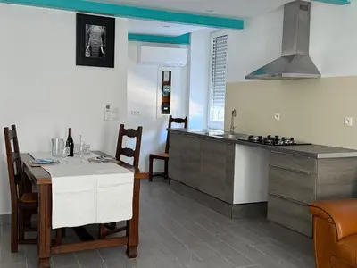 a kitchen and dining room with a table and a counter at La Turquoise in Caves