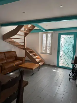 a living room with stairs and a couch and a window at La Turquoise in Caves