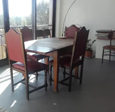a red couch in a living room with a chair at Chambre d'hôtes avec cuisine commune - 5 mns de Narbonne in Cuxac-dʼAude