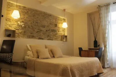 a bedroom with a bed and a stone wall at Le Logis GOUT in Carcassonne
