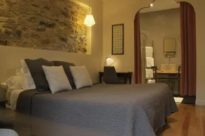 a bedroom with a bed with white pillows at Le Logis GOUT in Carcassonne
