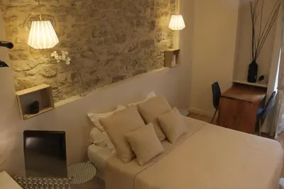 a bedroom with a bed with a laptop on it at Le Logis GOUT in Carcassonne