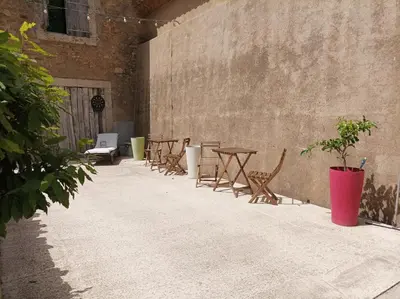 a row of tables and chairs next to a wall at Domaine Le Piboul in Fontcouverte