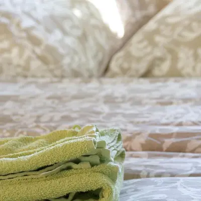 a stack of green towels sitting on a bed at Domaine Le Piboul in Fontcouverte