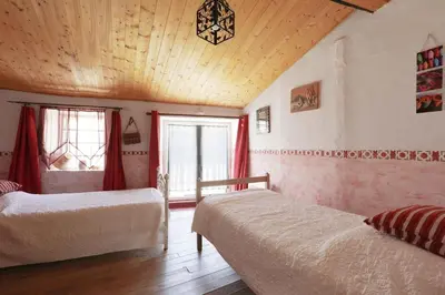 a bedroom with two beds and a wooden ceiling at Gîte les Hirondelles in Caudiès-de-Fenouillèdes