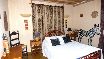 a bedroom with a bed and a zebra on the wall at Gîte les Hirondelles in Caudiès-de-Fenouillèdes