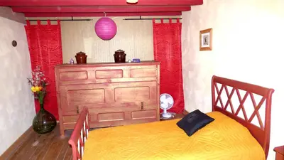 a bedroom with a bed and a wooden dresser at Gîte les Hirondelles in Caudiès-de-Fenouillèdes