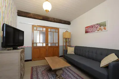 a living room with a couch and a tv at Gîte les Hirondelles in Caudiès-de-Fenouillèdes