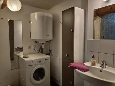 a bathroom with a washing machine and a sink at Fisherman's View in Bages