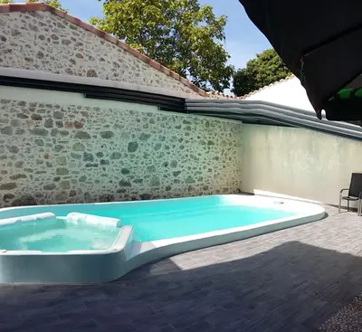 a hot tub sitting on a patio next to a wall at Palais Cathare in Bélesta