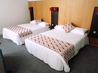 two beds in a hotel room with white sheets at Hôtel Restaurant de France in Castelnaudary