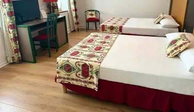 a hotel room with two beds and a desk and a desk at Hôtel Restaurant de France in Castelnaudary