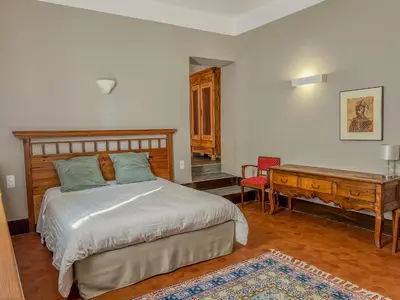 a bedroom with a bed and a wooden desk at Hôtel d'Alibert in Caunes-Minervois