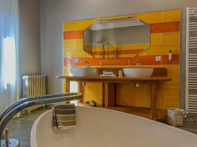 a bathroom with two sinks and a large tub at Hôtel d'Alibert in Caunes-Minervois