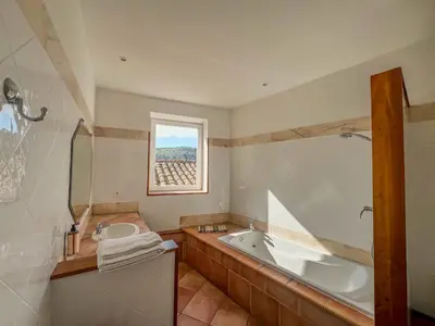 a bathroom with a tub and a sink at Hôtel d'Alibert in Caunes-Minervois