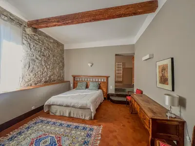 a bedroom with a bed and a table in it at Hôtel d'Alibert in Caunes-Minervois