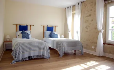 a bedroom with two beds with blue and white sheets at Jj French Gites in Pécharic-et-le-Py