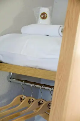 a bunk bed on a shelf with hangers at B&B HOTEL Narbonne 1 in Narbonne
