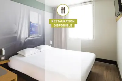 a bedroom with a white bed and a sign that reads restorationbuquerque at B&B HOTEL Narbonne 2 in Narbonne