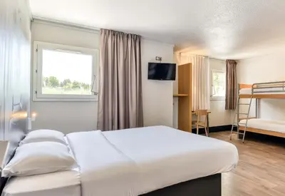 a hotel room with a bed and a bunk bed at B&B HOTEL Narbonne 2 in Narbonne