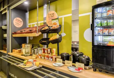 a bakery with a counter with bread and other food at B&B HOTEL Narbonne 2 in Narbonne