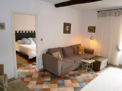 a living room with a couch and a bed at Maison de la Place in Saint-Chinian
