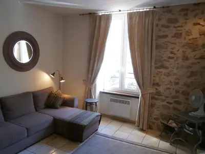 a living room with a couch and a large window at Maison de la Place in Saint-Chinian