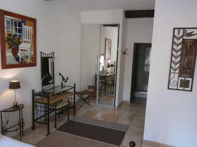 a room with a table and chairs and a mirror at Maison de la Place in Saint-Chinian