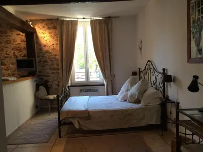 a bedroom with a bed and a window at Maison de la Place in Saint-Chinian