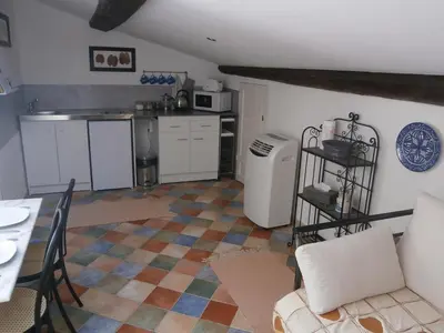 a kitchen with a couch and a table in a room at Maison de la Place in Saint-Chinian