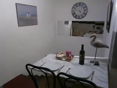 a table with a bird sitting on a table with a bottle of wine at Maison de la Place in Saint-Chinian