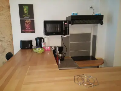 a kitchen with a wooden table and a counter top at Appartements Cote pont Vieux-Self Check-In in Carcassonne