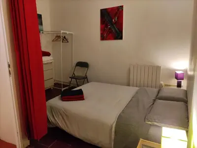 a small bedroom with a bed and a chair at Appartements Cote pont Vieux-Self Check-In in Carcassonne