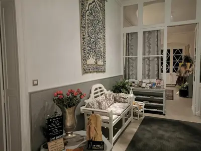 a living room with a white chair and a vase of flowers at Château de Verdalle in Verdalle