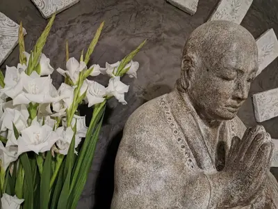 a statue next to a bunch of white flowers at Château de Verdalle in Verdalle