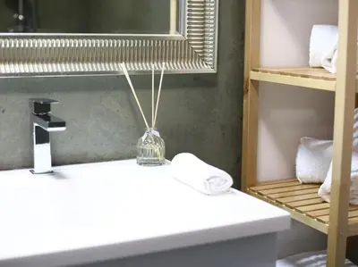a bathroom with a sink and a mirror and towels at Maison Bacou cité 3 in Carcassonne