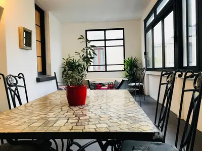 a table with plants on it in a room with windows at Les Chambres du Palais in Carcassonne