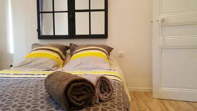 a bedroom with a bed with pillows and a window at Les Chambres du Palais in Carcassonne