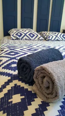 a blue and white bed with towels on it at Les Chambres du Palais in Carcassonne