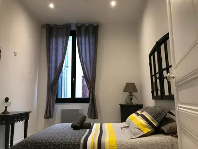 a bedroom with a bed and a window at Les Chambres du Palais in Carcassonne