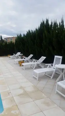 a row of white lounge chairs sitting on a patio at Nina in Carcassonne