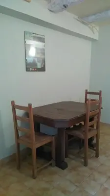 a wooden table and two chairs in a room at Gîte de Rouayras in Nages