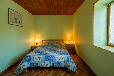 a bedroom with a bed with a blue comforter at Gîte de Rouayras in Nages