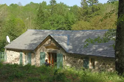 a person sitting in a window of a stone house at Gîte de Rouayras in Nages