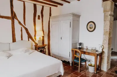 a bedroom with a bed and a desk and a table at Cuq en Terrasses in Cuq-Toulza